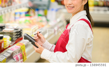 ハンディターミナルを持つ女性店員 138945591