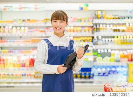 笑顔で商品を持つ女性店員 138945594