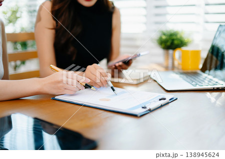 Business documents on office table with smart phone and calculator digital tablet and graph business with social network diagram and two colleagues discussing data working in the office Business documents on office table with smart phone and calculator digital tablet and graph business with social network diagram and two colleagues discussing data working in the office 138945624