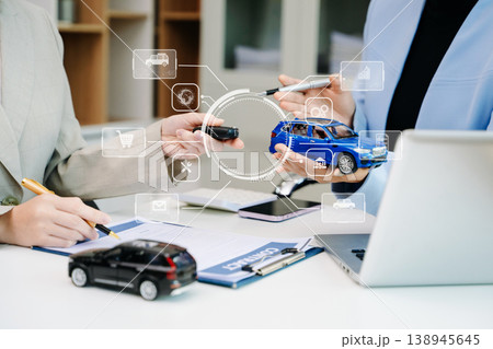 Car saleswoman handing over car key to customer at showroom. Vehicle purchase, auto finance, contract signing and successful car sales business concept. Car saleswoman handing over car key to customer at showroom. Vehicle purchase, auto finance, contract signing and successful car sales business concept. 138945645
