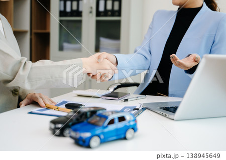 Car saleswoman handing over car key to customer at showroom. Vehicle purchase, auto finance, contract signing and successful car sales business concept. Car saleswoman handing over car key to customer at showroom. Vehicle purchase, auto finance, contract signing and successful car sales business concept. 138945649