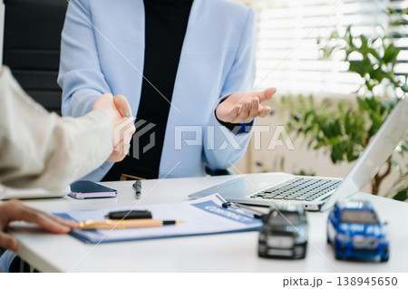 Car saleswoman handing over car key to customer at showroom. Vehicle purchase, auto finance, contract signing and successful car sales business concept. Car saleswoman handing over car key to customer at showroom. Vehicle purchase, auto finance, contract signing and successful car sales business concept. 138945650