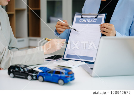 Car insurance contract signing with financial advisor. Customer reviewing agreement with car model on desk, representing auto insurance, finance, loan 138945673