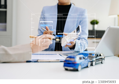 Professionals reviewing a car accident claim with model vehicles, illustrating auto insurance, risk assessment, and financial consultation in office 138945693