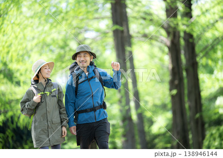 森の中を歩く夫婦のアウトドアシーン、登山やトレッキングなどの運動のイメージ 138946144