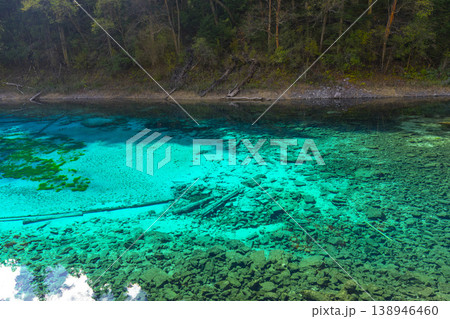 Fantastic view of the Five Colored Pool (the Colorful Pond) with azure crystal clear water among fall woods and evergreen forest in Jiuzhai Valley National Park in China. Fantastic view of the Five Colored Pool (the Colorful Pond) with azure crystal clear water among fall woods and evergreen forest in Jiuzhai Valley National Park in China. 138946460