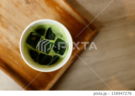 Cup of fresh iced matcha tea, green tea on wooden tray. 138947276