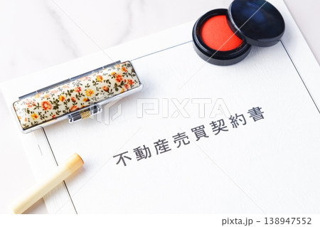 不動産を売買する契約の際に交わす不動産売買契約書と印鑑、朱肉で、不動産の売買契約のイメージ 138947552