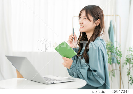 オフィスオフィス,仕事場でメモ帳,ネタ帳を見る笑顔の若いアジア人女性 オフィスオフィス,仕事場でメモ帳,ネタ帳を見る笑顔の若いアジア人女性 138947845