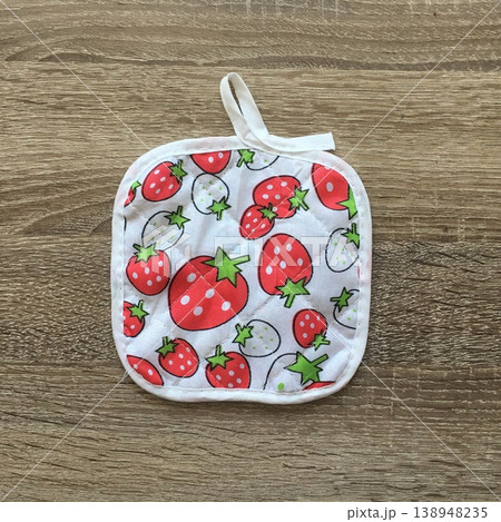 Colorful kitchen towel with strawberry design placed on a wooden table showing the kitchen item and its vibrant pattern Colorful kitchen towel with strawberry design placed on a wooden table showing the kitchen item and its vibrant pattern 138948235