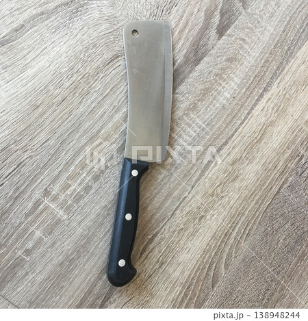 Sharp kitchen knife laying on wooden surface near cutting area 138948244