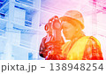 A geodesic engineer performs close-up survey work on a construction site behind a geodetic instrument. 138948254