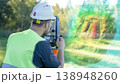 An engineer at work on a geodetic instrument. Geodesy surveying is the cadastral work of performing measurements of premises using a modern total station geodetic instrument. 138948260