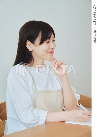 献立をメモする女性 食事準備や日常の計画を立てるシーン 献立をメモする女性 食事準備や日常の計画を立てるシーン 138948327