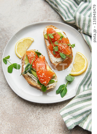 Salmon avocado toasts with cream cheese and microgreens Salmon avocado toasts with cream cheese and microgreens 138948479