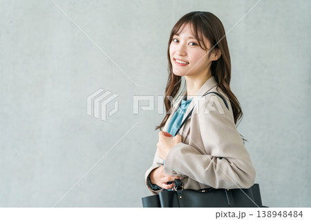 バックを持って歩くスーツ姿の若いアジア人女性(オフィスカジュアル) バックを持って歩くスーツ姿の若いアジア人女性(オフィスカジュアル) 138948484