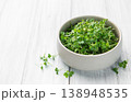 Fresh microgreens in bowl on white wooden table 138948535