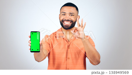 Man, portrait and ok for phone with green screen, space or agreement in studio on white background. Happy model, smartphone or yes emoji for certified newsletter, promotion or advertising information 138949569
