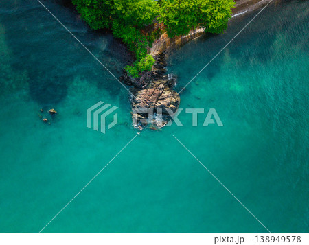 Top down aerial view of a rocky cape and crystal clear emerald sea water. Top down aerial view of a rocky cape and crystal clear emerald sea water. 138949578