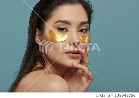 Well groomed girl applying under eyes mask with patches. Well groomed girl applying under eyes mask with patches. 138949850