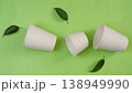 Biodegradable cups on green background with leaves 138949990