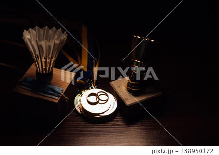 Badminton Pandemic Wedding Concept with Shuttlecock Awards, Mask, and Gold Rings on Wood. Badminton Pandemic Wedding Concept with Shuttlecock Awards, Mask, and Gold Rings on Wood. 138950172
