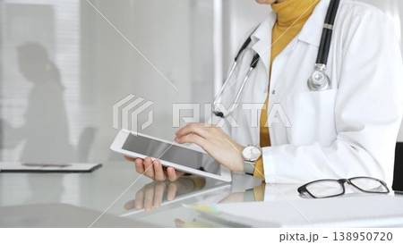 Female doctor using digital tablet, providing modern healthcare and medical technology consultation. Medicine, healthcare and science concept 138950720
