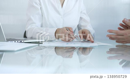 Business partners or lawyers are analyzing documents and collaborating on a project during a productive office meeting while sitting at the glass table. Businesspeople concept 138950729