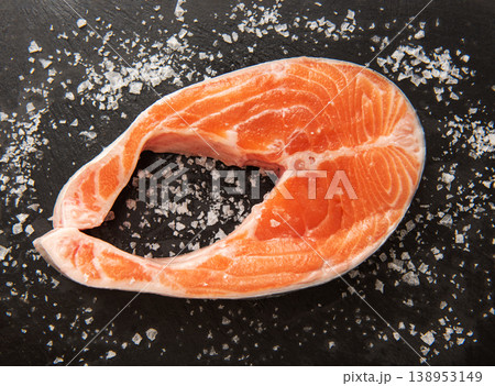 Fresh salmon steak with coarse salt on a black background 138953149