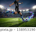 黒ユニフォームのサッカー選手のキックアクションと虹色の渦巻く幾何学破片エフェクト・イラスト 138953190