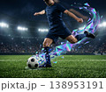 サッカー選手のシュートアクションと虹色の幾何学破片エフェクト・スタジアム背景イラスト 138953191