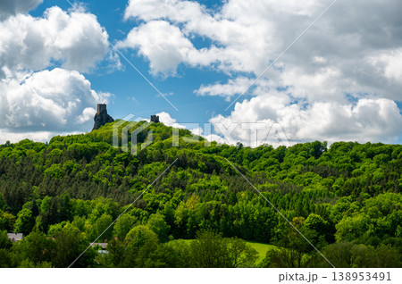 Panoramic view of Cesky Raj landscape in summer with iconic Trosky castle towers rising above green countryside under blue sky with dramatic clouds summer scenic natureview stock Panoramic view of Cesky Raj landscape in summer with iconic Trosky castle towers rising above green countryside under blue sky with dramatic clouds summer scenic natureview stock 138953491
