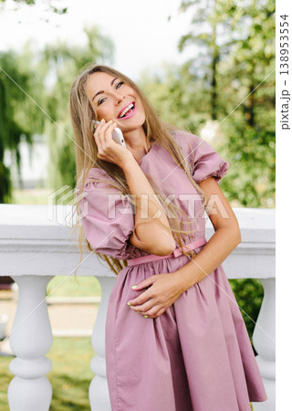 Cheerful Young Woman Chatting On Phone Outside 138953554