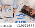 Hands working on financial reports and laptop 138953685