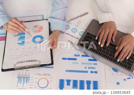 Hands working on financial reports and laptop Hands working on financial reports and laptop 138953685