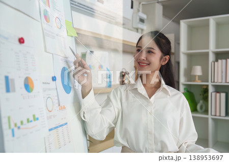 Businesswoman analyzing data on a whiteboard in an office 138953697
