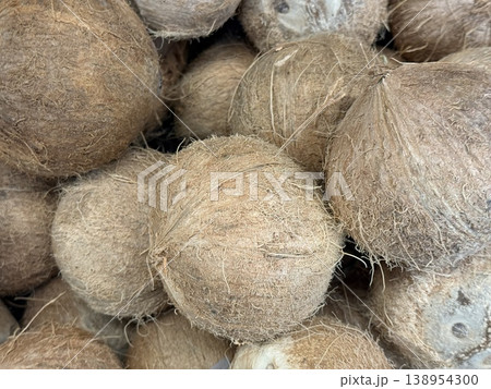 Coconuts with rough texture arranged in a pile suitable for tropical background or food concept Coconuts with rough texture arranged in a pile suitable for tropical background or food concept 138954300