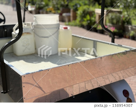 Open utility cart with empty white buckets and a jerry can on a sunny day Open utility cart with empty white buckets and a jerry can on a sunny day 138954307