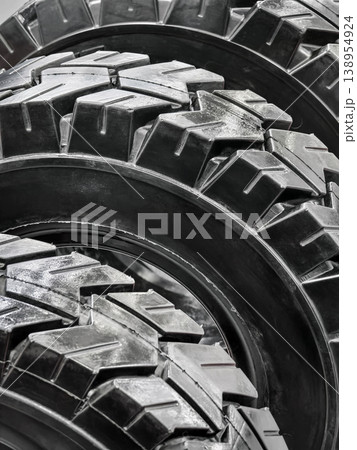 Close up view of new off-road tires stacked together at a workshop in bright daylight showing detailed tread patterns for traction and performance Close up view of new off-road tires stacked together at a workshop in bright daylight showing detailed tread patterns for traction and performance 138954924