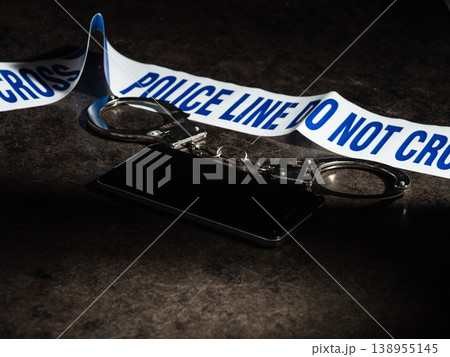 Mobile phone evidence and police handcuffs on desk 138955145