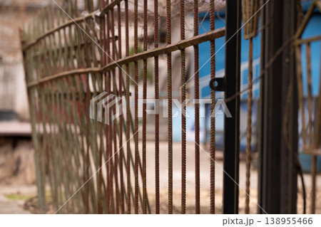 Rusty Rebar Metal Fence with Vertical Iron Rods and Blurred Background in Industrial Style 138955466