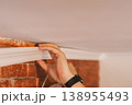 Close up applying construction adhesive to molding strip, DIY home improvement concept 138955493