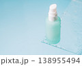 Minimal pump bottle on blue background with glass and water drops 138955494