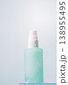 Frosted skincare pump bottle standing on glass shelf in soft light 138955495