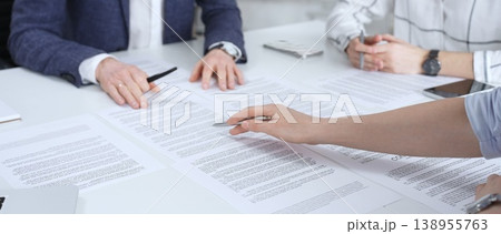Business people discussing contract terms, outlining agreements, and reviewing legal documents during a corporate meeting, preparing for a significant partnership signing and negotiation 138955763