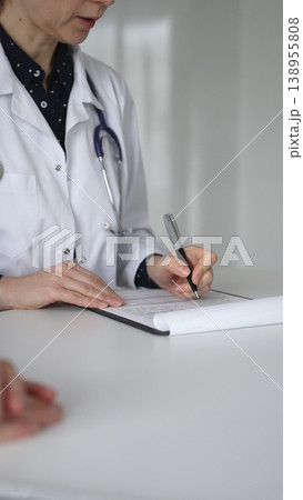 Experienced female doctor consulting patient man, providing medical advice and writing prescription during hospital appointment. Medicine, healthcare and science concept 138955808