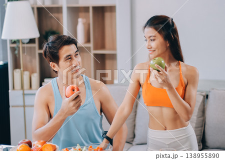 A happy couple prepares fresh vegetables, laughing and enjoying cooking a healthy meal together. 138955890