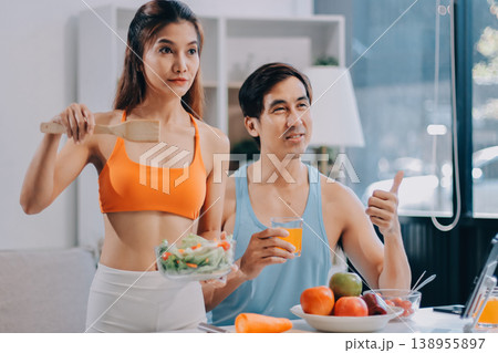 A happy couple prepares fresh vegetables, laughing and enjoying cooking a healthy meal together. A happy couple prepares fresh vegetables, laughing and enjoying cooking a healthy meal together. 138955897