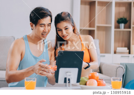 A happy couple prepares fresh vegetables, laughing and enjoying cooking a healthy meal together. A happy couple prepares fresh vegetables, laughing and enjoying cooking a healthy meal together. 138955918