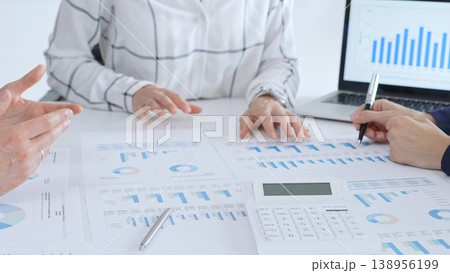Business professionals analyzing financial data and market trends during a corporate meeting, collaborating on reports and planning strategic growth in the office Business professionals analyzing financial data and market trends during a corporate meeting, collaborating on reports and planning strategic growth in the office 138956199